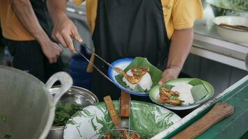 close up of a person serving a meal of rice with two servings of fried chicken photo