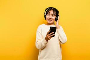 Asian woman happily using the phone and listening to music Relaxing with music. On a comfortable day. Dance and relaxation concept. listening to music online photo