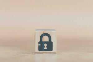 cyber security wood cube concept man hand laying down a wood cube with a padlock icon to convey protection  with danger to data and assets photo