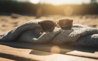 Still life photo of sunglasses over a beach towel and sand. Summer still life concept. .