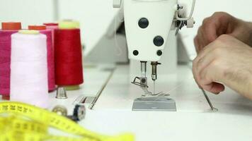 de coser hilos con sastre manos y de coser máquina, Sastre cambiando y ajustando hilos en de coser máquina, selectivo atención video