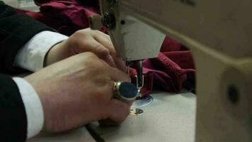 Tailor sews fabric with sewing machine video