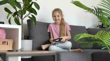 weinig meisje spelen internet video spel gebruik makend van afgelegen controleur