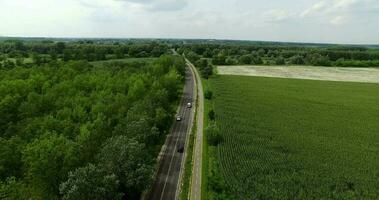 Aerial shot of highway and vehicle traffic advancing with nature scenery, vehicles moving on highway passing through green nature video