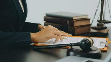 Business and lawyers discussing contract papers with brass scale on desk in office. Law, legal services, advice, justice and law concept picture with film grain effect video