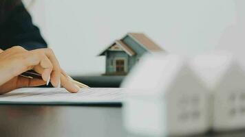 Female woman hands holding home model, small miniature white toy house. Mortgage property insurance dream moving home and real estate concept video