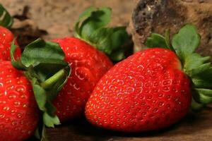 Fresh strawberry close up on wooden background. Macro strawberry photo