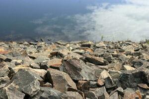 The lake which shows the shadow of the white cloud and blue sky surrounding Rock stone stage Landscape photo