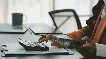 Financial analysts analyze business financial reports on a digital tablet planning investment project during a discussion at a meeting of corporate showing the results of their successful teamwork. video