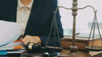 Business and lawyers discussing contract papers with brass scale on desk in office. Law, legal services, advice, justice and law concept picture with film grain effect video