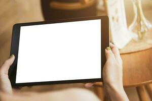 mujer participación digital tableta con blanco blanco escritorio pantalla en café tienda para Copiar y diseño foto