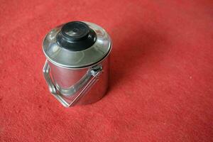 silver stainless teapot with red background photo