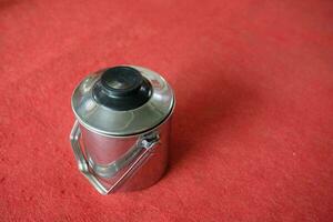 silver stainless teapot with red background photo