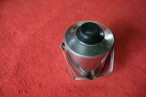 silver stainless teapot with red background photo