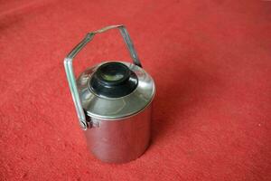 silver stainless teapot with red background photo