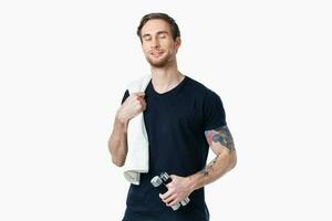 sports man in a black t-shirt with dumbbells in his hands fitness exercises photo