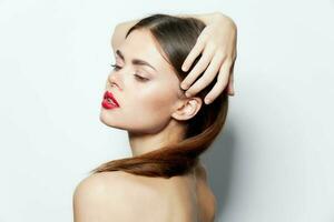 Woman naked shoulders attractive look red lips holds hand on head natural look photo