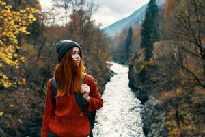 woman with hands raised up on nature in the mountains Autumn forest photo