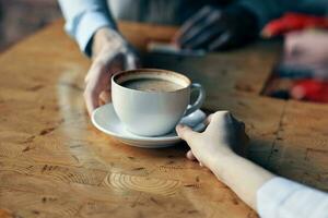 el cocinero sirve el cliente un taza de café con un platillo en el mesa y un restaurante bebida foto