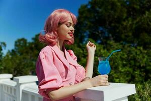 alegre mujer con rosado pelo verano cóctel refrescante bebida inalterado foto