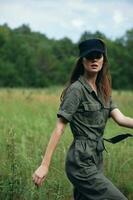 mujer en el campo en un verde traje, un negro viaje gorra, Fresco aire foto