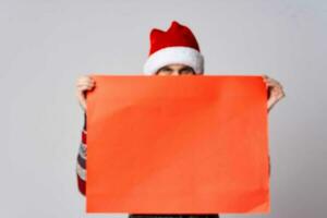 Cheerful man in a christmas hat with Red mockup poster light background photo