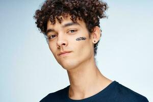 Cheerful man with curly hair cosmetics on face clean skin photo