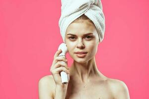 woman with towel on head naked shoulders massager dermatology spa treatments photo