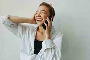 Adolescente niña sonriente y riendo hablando en el teléfono, vídeo llamar, chateando en línea foto