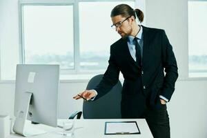 masculino gerente en el oficina gestos con su manos computadora foto