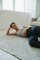 Teenage girl lying on the floor at home smiling in home clothes with a short haircut, lifestyle without filters, free copy space photo