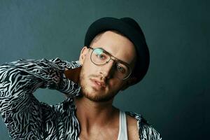 handsome man in hat fashion shirt posing dark background photo