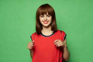 Happy woman on a green background in a red tank top smiles photo