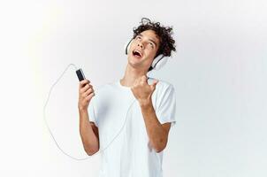 emotional man in white t-shirt listening to music with headphones cropped view photo