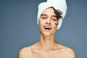 guy with bare shoulders with a towel on his head photo