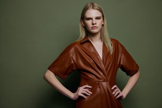 Women's Day concept. Stylish fashion self-confident young blonde woman holding hands on waist posing isolated on over olive green wall background looks at camera. Fashion offer for brands banner photo