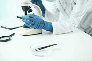 hembra médico mirando mediante un microscopio biotecnología investigación laboratorio foto