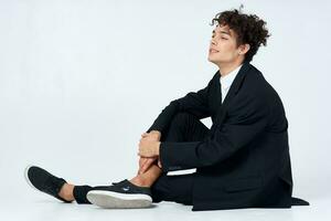 guy with curly hair in a suit sitting on the floor fashion self-confidence photo