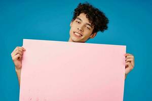 cute guy holding mockup poster advertising copy space blue background photo