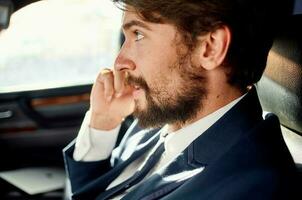 business man with a beard talking on the phone in a car trip photo