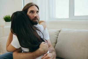 A man hugs his Asian woman friend at home. Psychological support for a friend photo