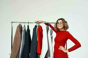 pretty woman in a red jacket near the wardrobe retail isolated background photo