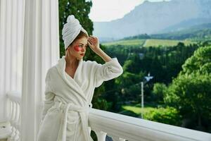 Sensual and beautiful woman in a white robe the balcony overlooks the mountains unaltered photo