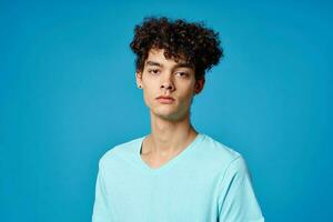 guy with curly hair in blue t-shirt cropped view studio photo