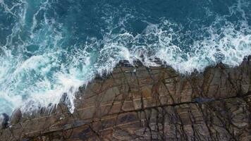mar olas salpicaduras en costero acantilado en arteixo, coruña, España. aéreo De arriba hacia abajo video