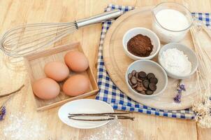 Top View Baking Preparation on wooden Table,Baking ingredients. Bowl, eggs and flour, rolling pin and eggshells on wooden board,Baking concept photo