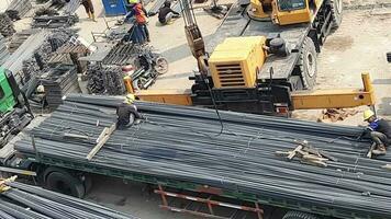 Jakarta, Indonesia in March 2023. Several construction workers who are blacksmiths are unloading iron from the trailer. Lowering of iron is assisted by using a service crane. video