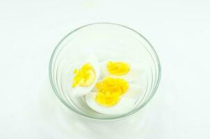 sliced hard boiled eggs in cup on  white background. photo