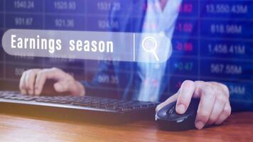 Earnings season Hand touching of written in search bar with the financial data visible in the background,  Reports Stock Market Ticker Words photo