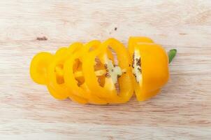 sliced Yellow bell peppers on wooden cutting board photo